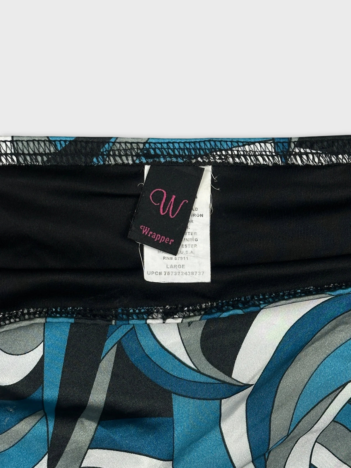 Detail view of a women's skirt featuring a blue abstract pattern and black trim.