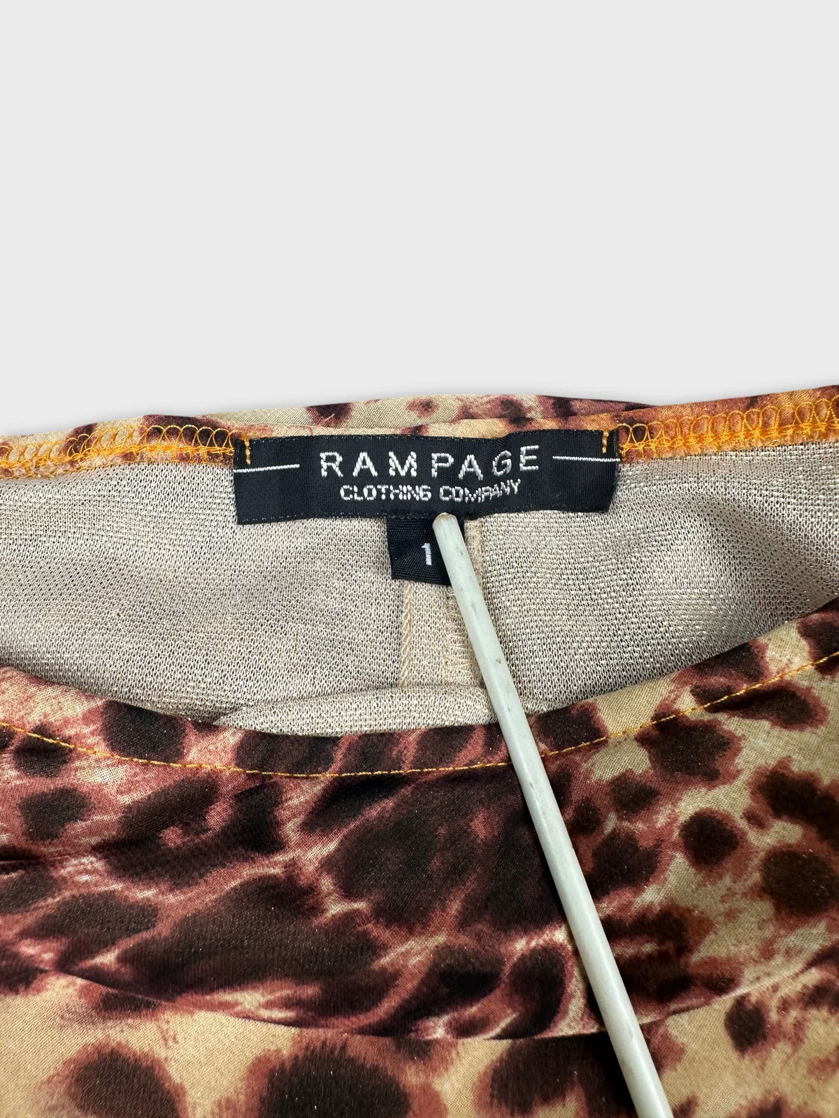 Detail view of a brown leopard print skirt with visible waistband and tag.