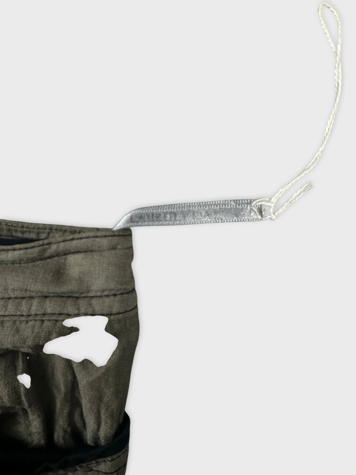 Detail view of a women's skirt in olive green with a distressed pattern.