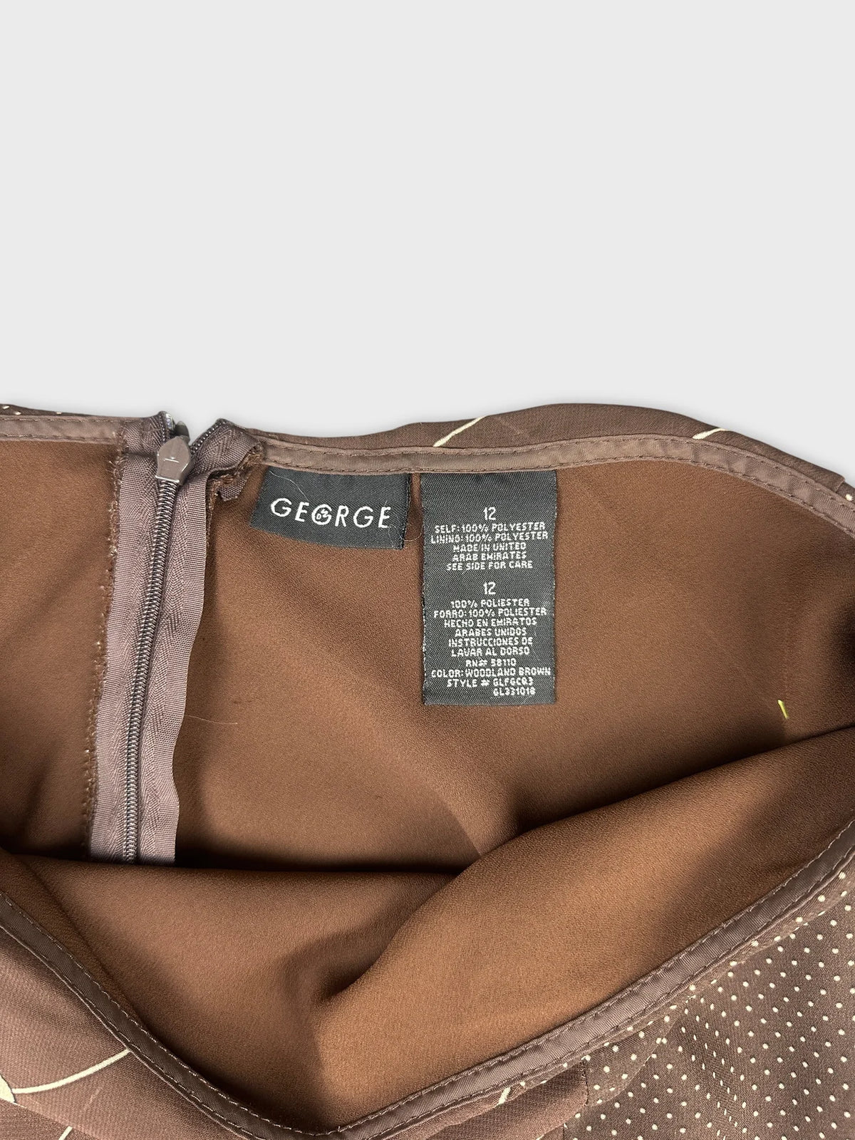 Detail view of a brown vintage skirt featuring a subtle polka dot pattern.