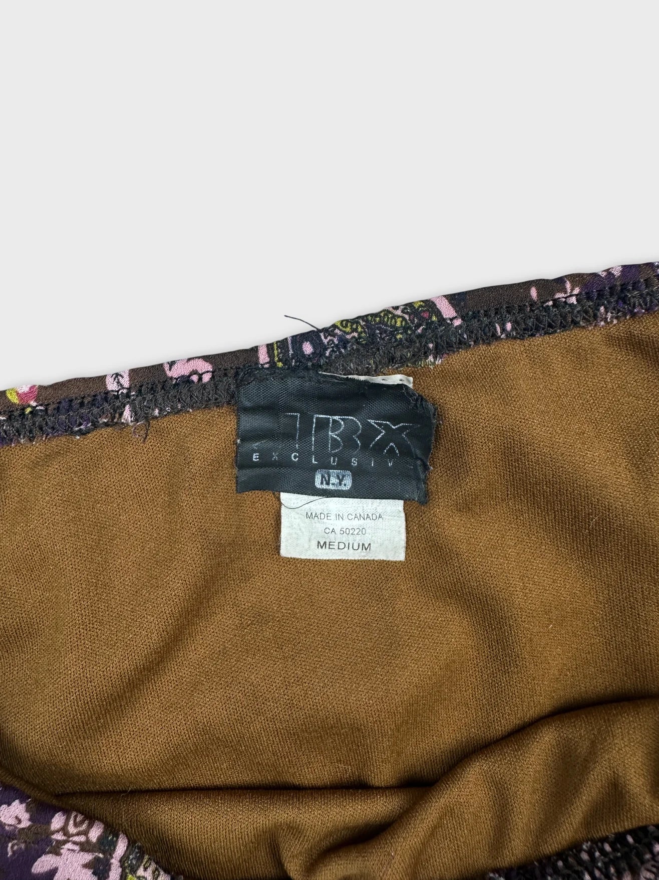 Detail view of a vintage skirt in brown with floral trim.