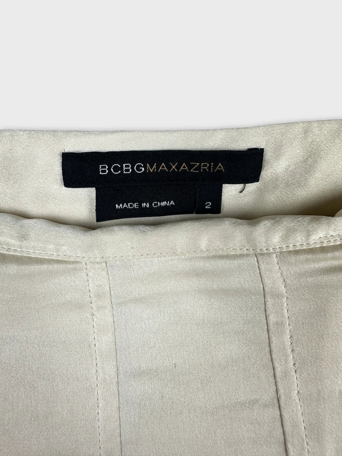 Detail view of a cream skirt featuring a clean finish and hidden zipper.