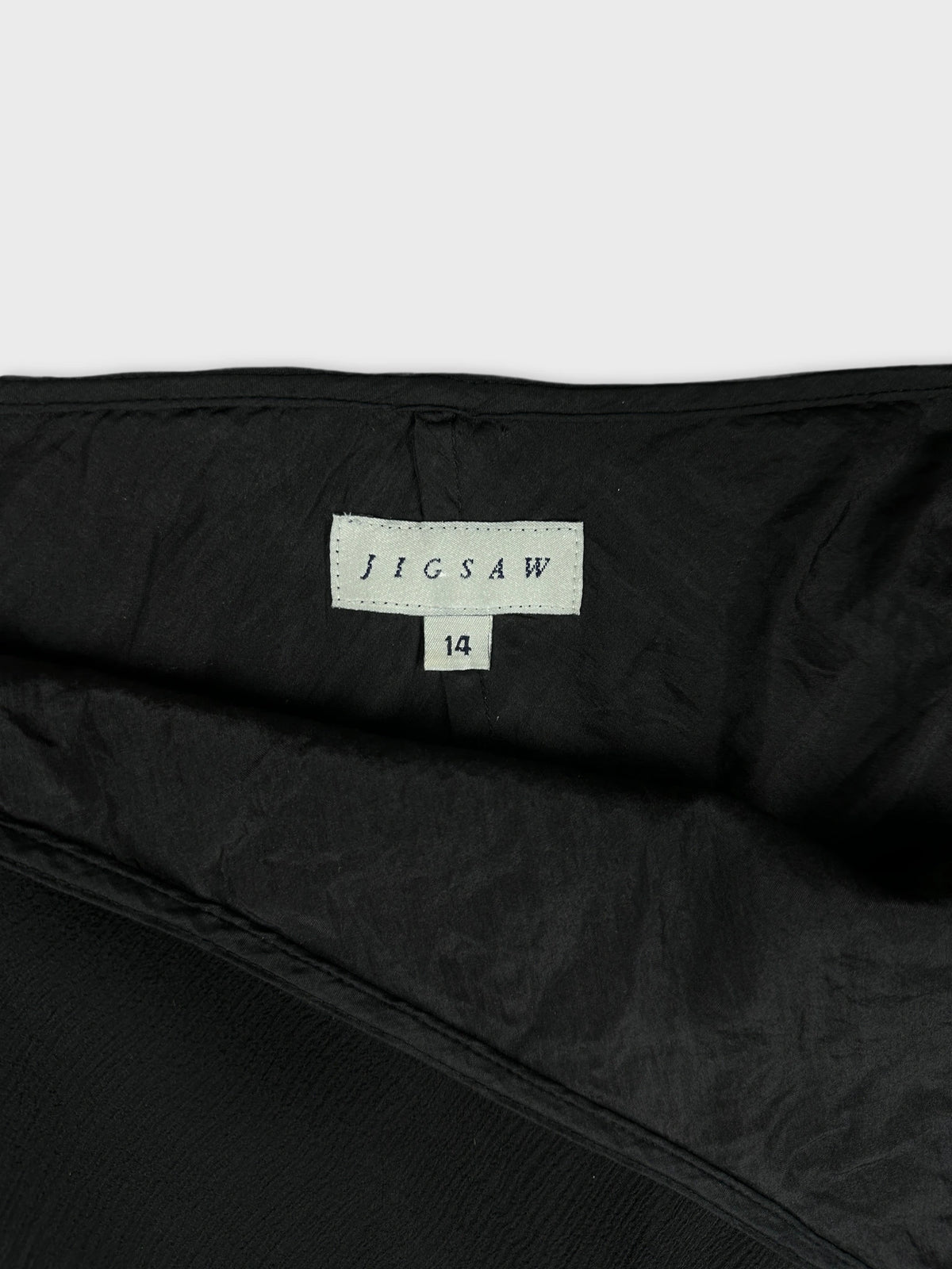 Black skirt inside view with brand label and smooth texture detail view