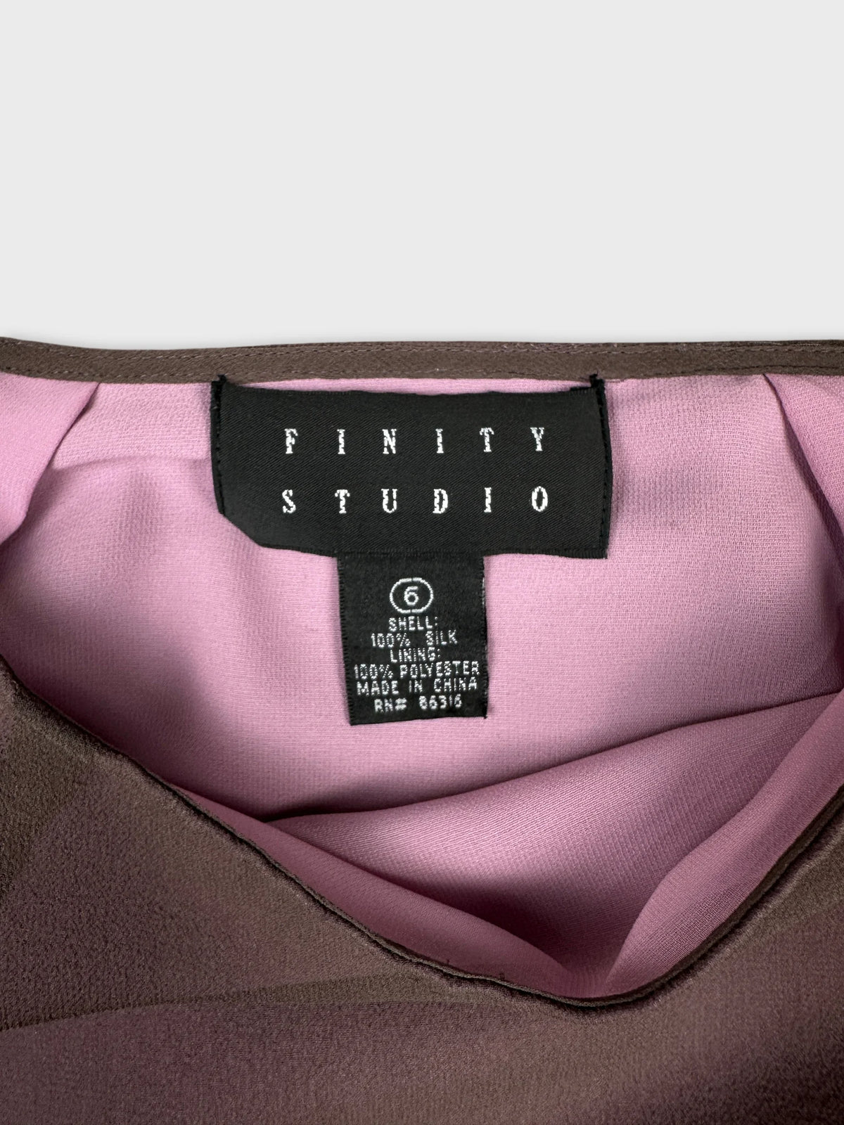 Detail view of a brown skirt with pink lining and label.