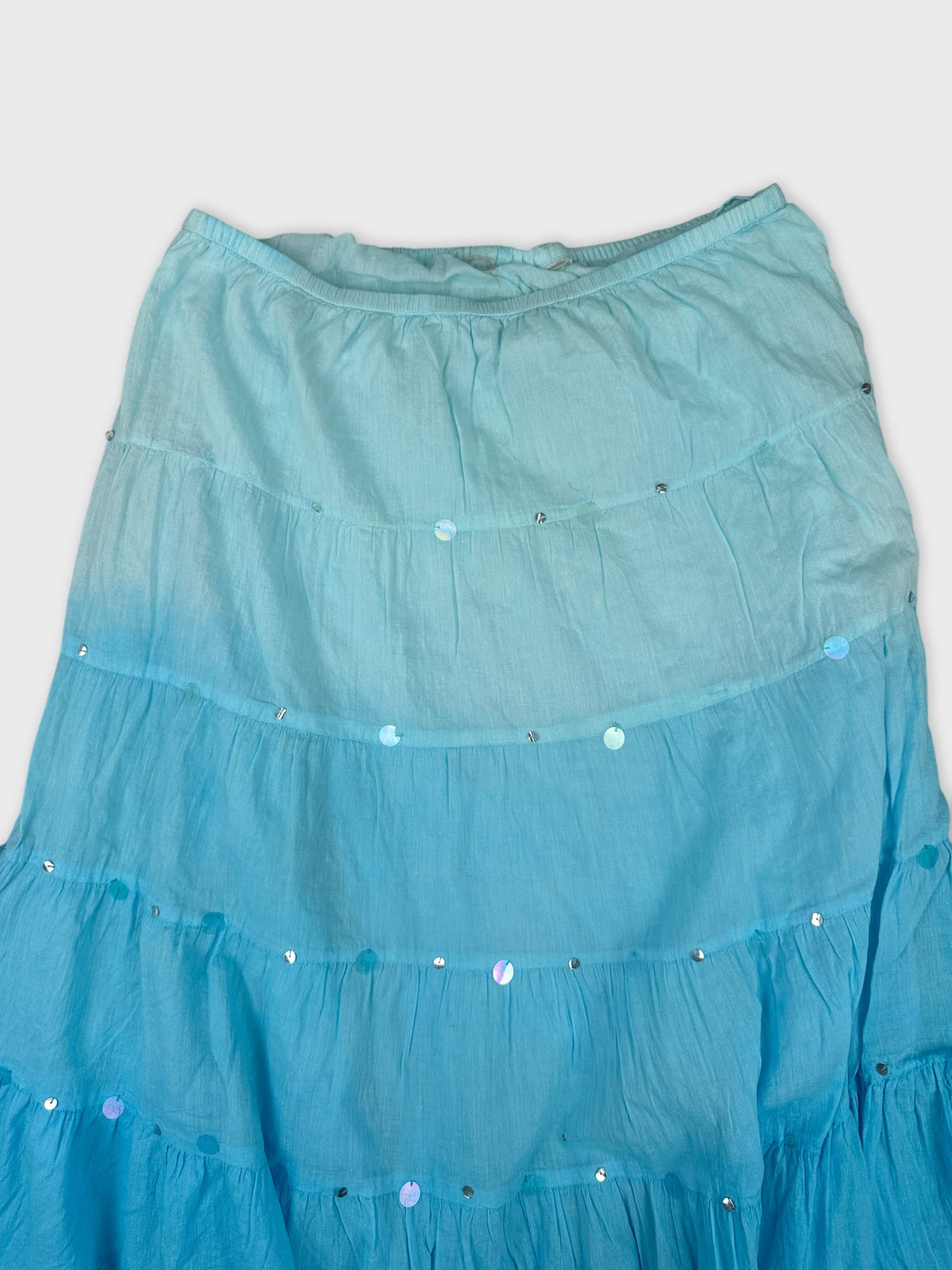 Detail view of a women's skirt in light teal with silver sequins.