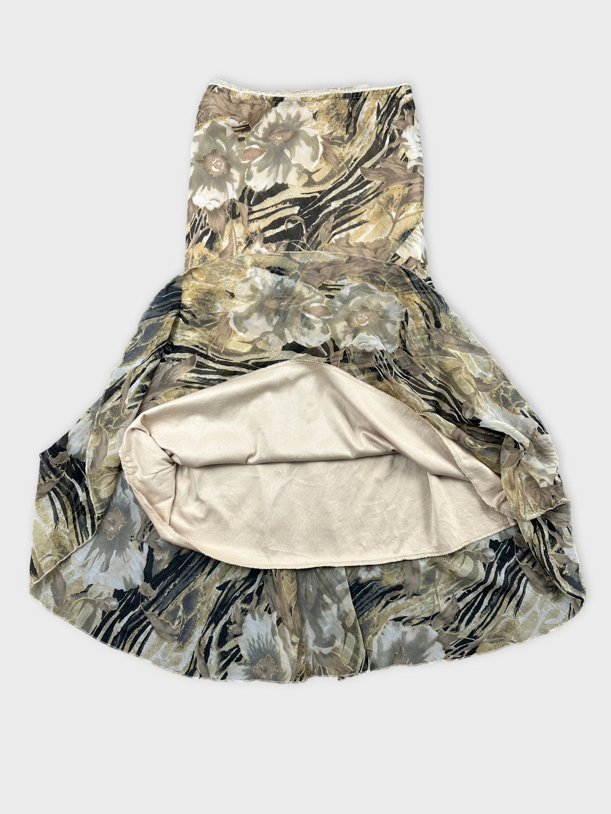 Detail view of a floral skirt in beige with a ruffled hem.