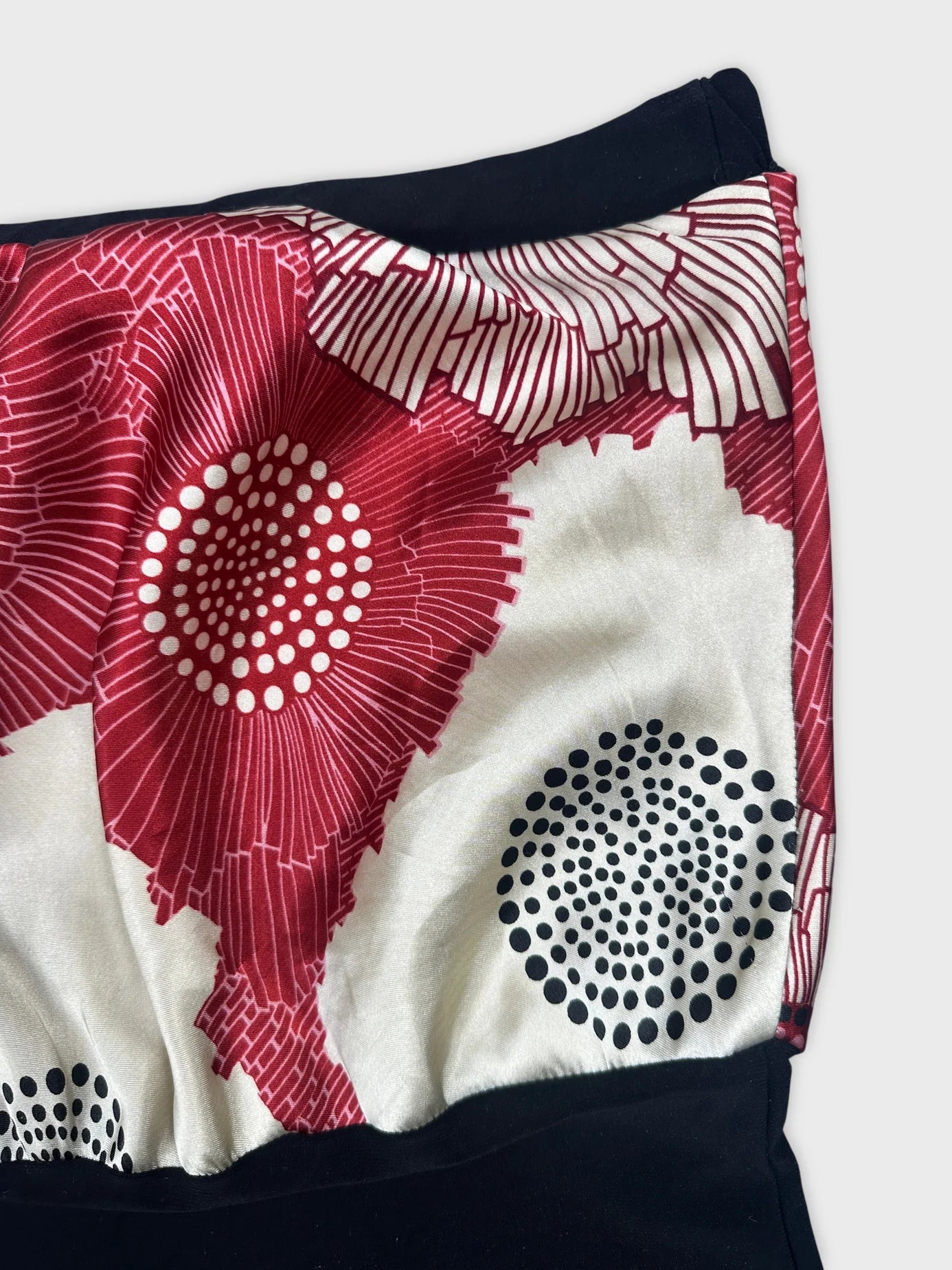 Detail view of a vintage skirt in red and white floral pattern.