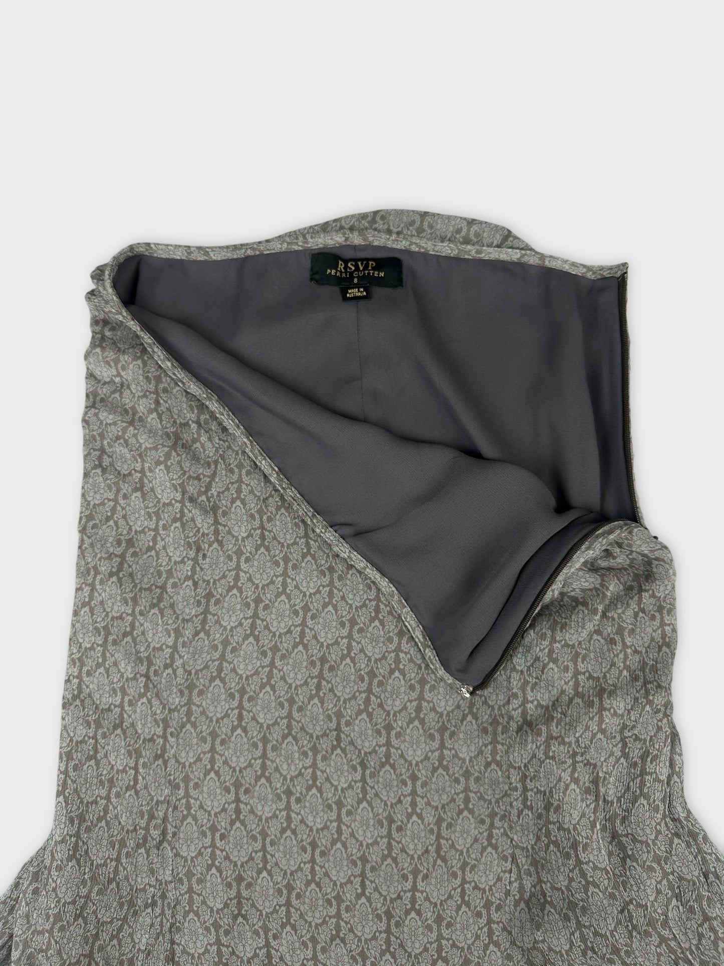 Detail view of a grey vintage skirt with floral pattern and interior lining.
