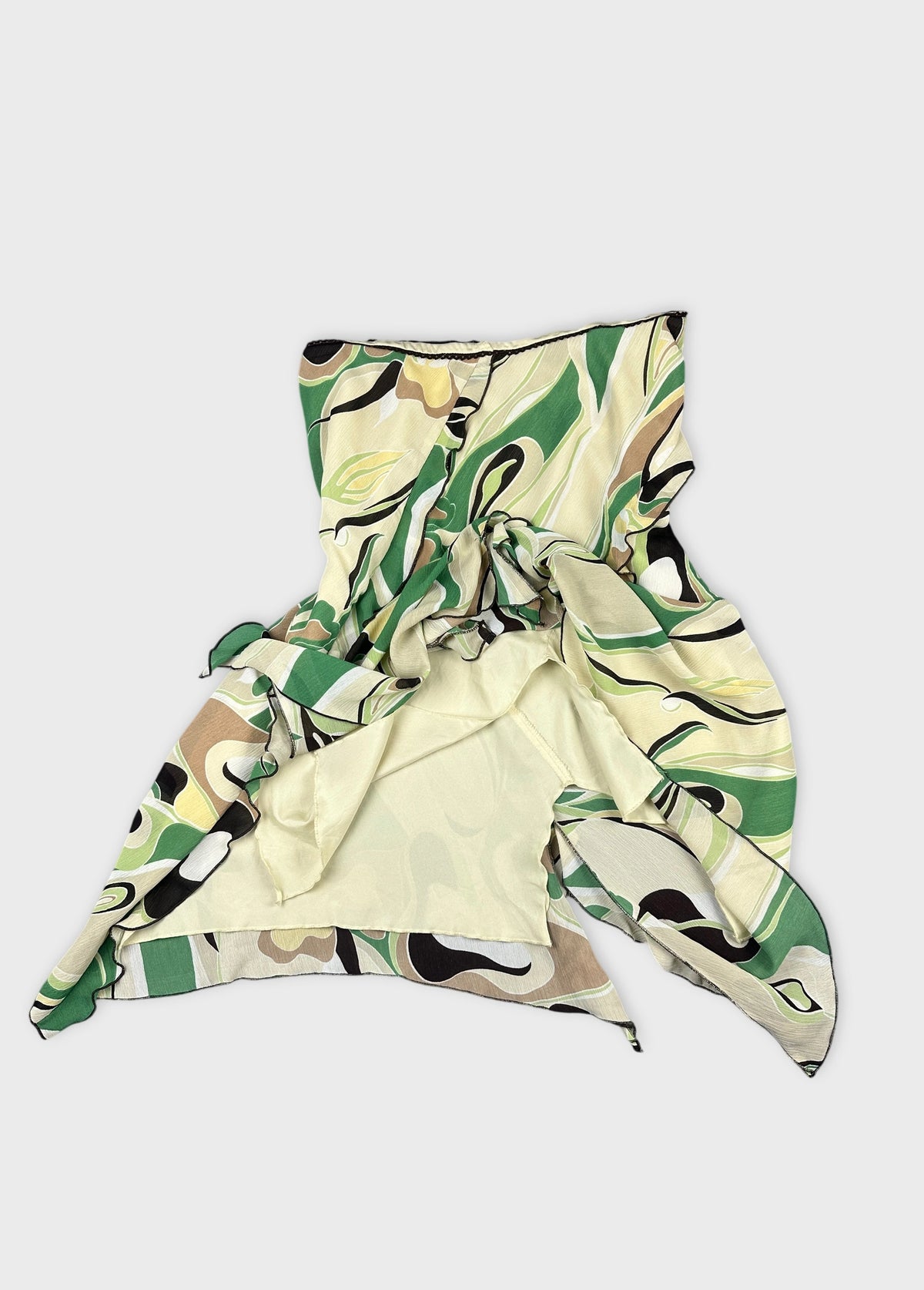 Detail view of a green and beige patterned skirt with flowing design.