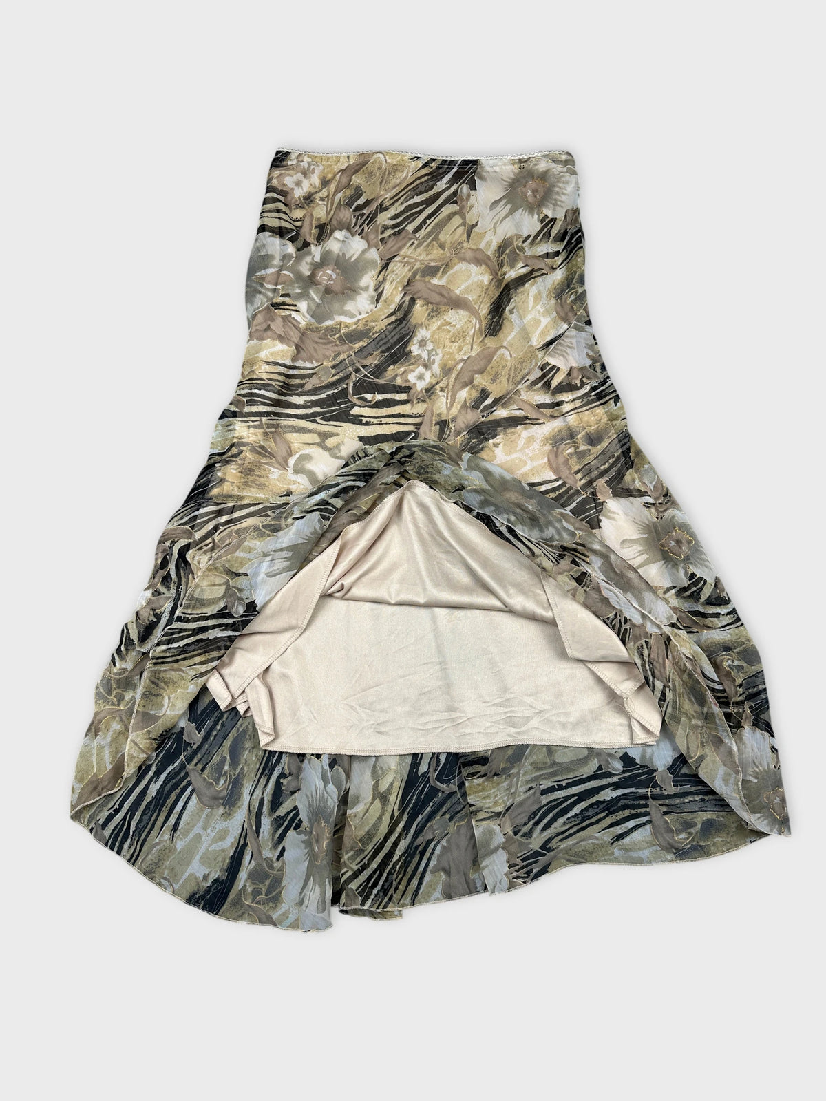 Detail view of a floral skirt in earthy tones with a ruffled hem.