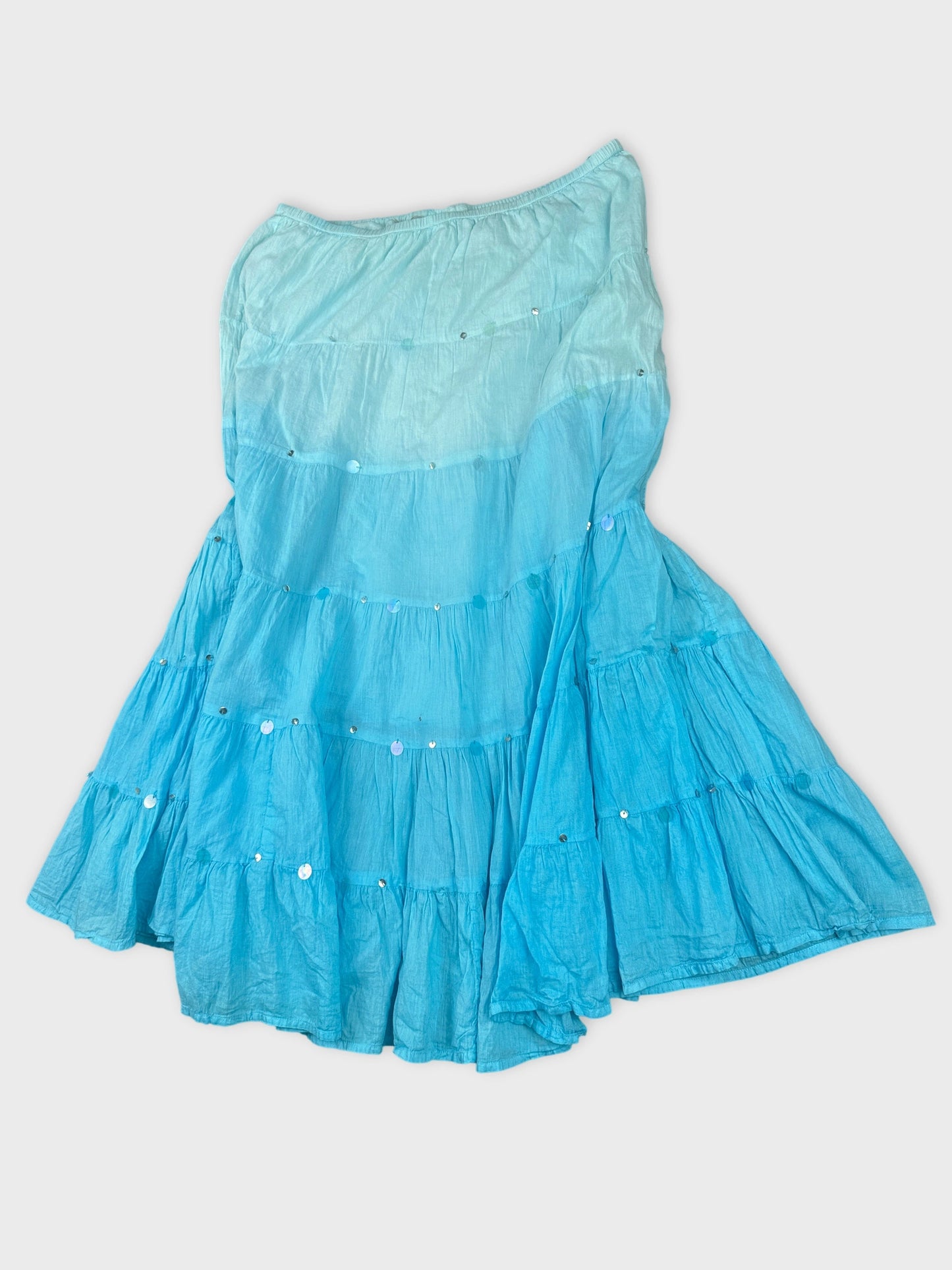 Detail view of a blue tiered skirt with shiny embellishments.