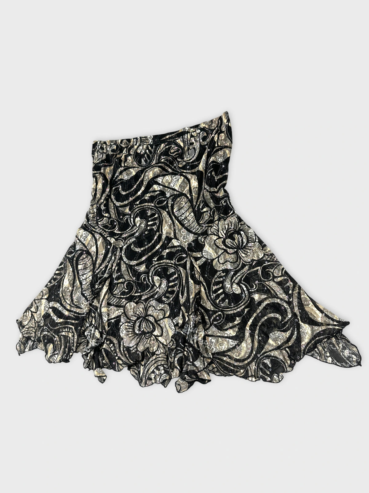Detail view of a black vintage skirt with floral silver pattern.