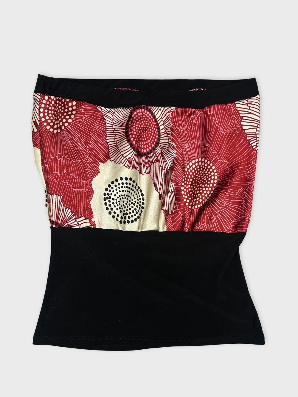 Front view of a vintage skirt with a red floral pattern and black bottom.