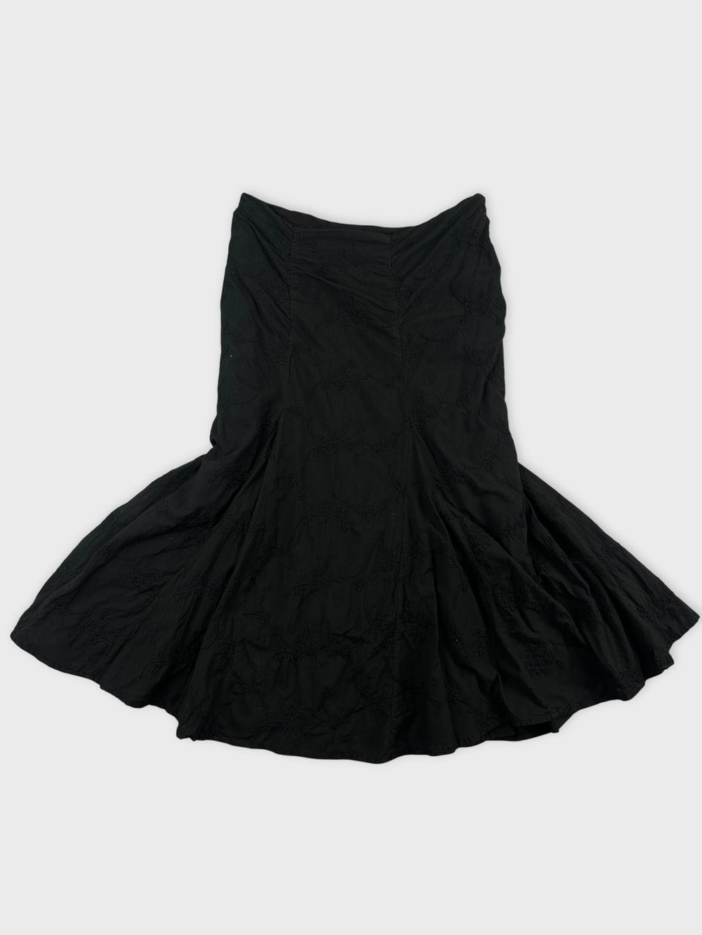 Front view of a black skirt with textured floral pattern.