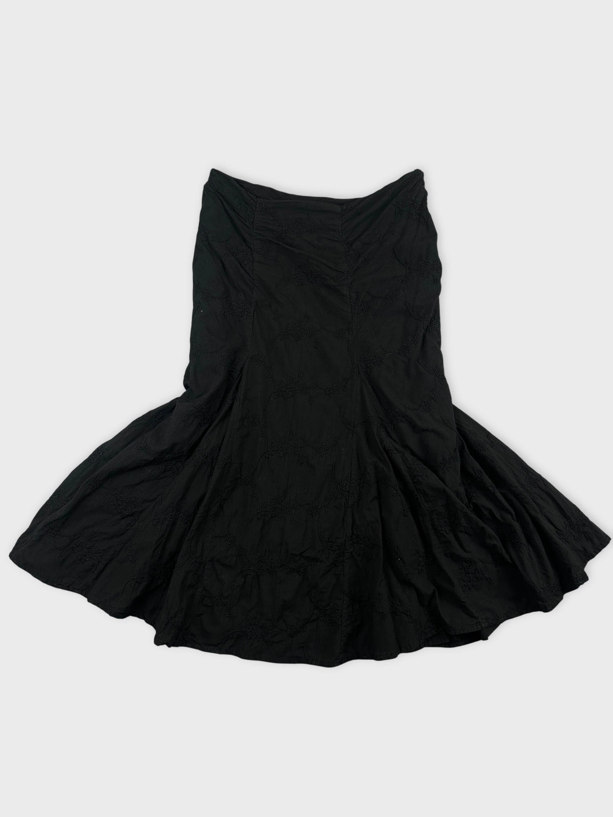 Front view of a black skirt with textured floral pattern.