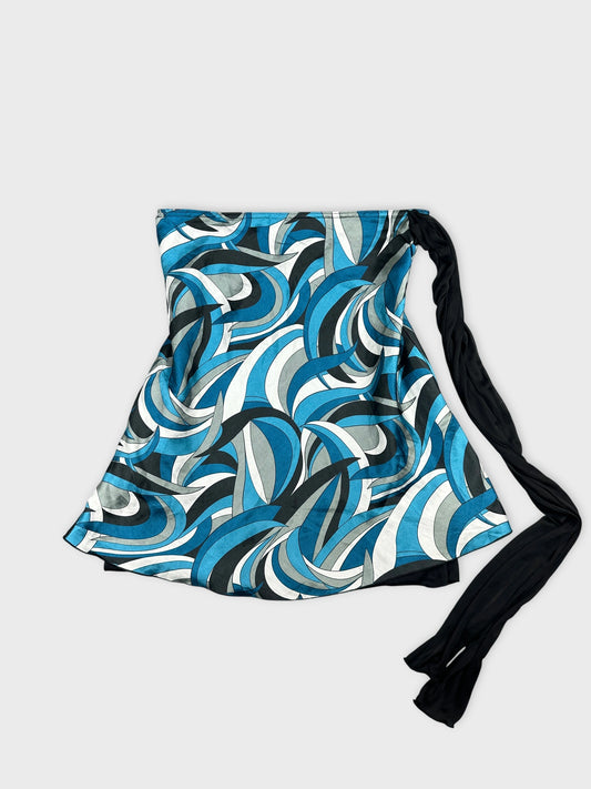 Front view of a blue patterned skirt featuring wave-like designs and a black tie.