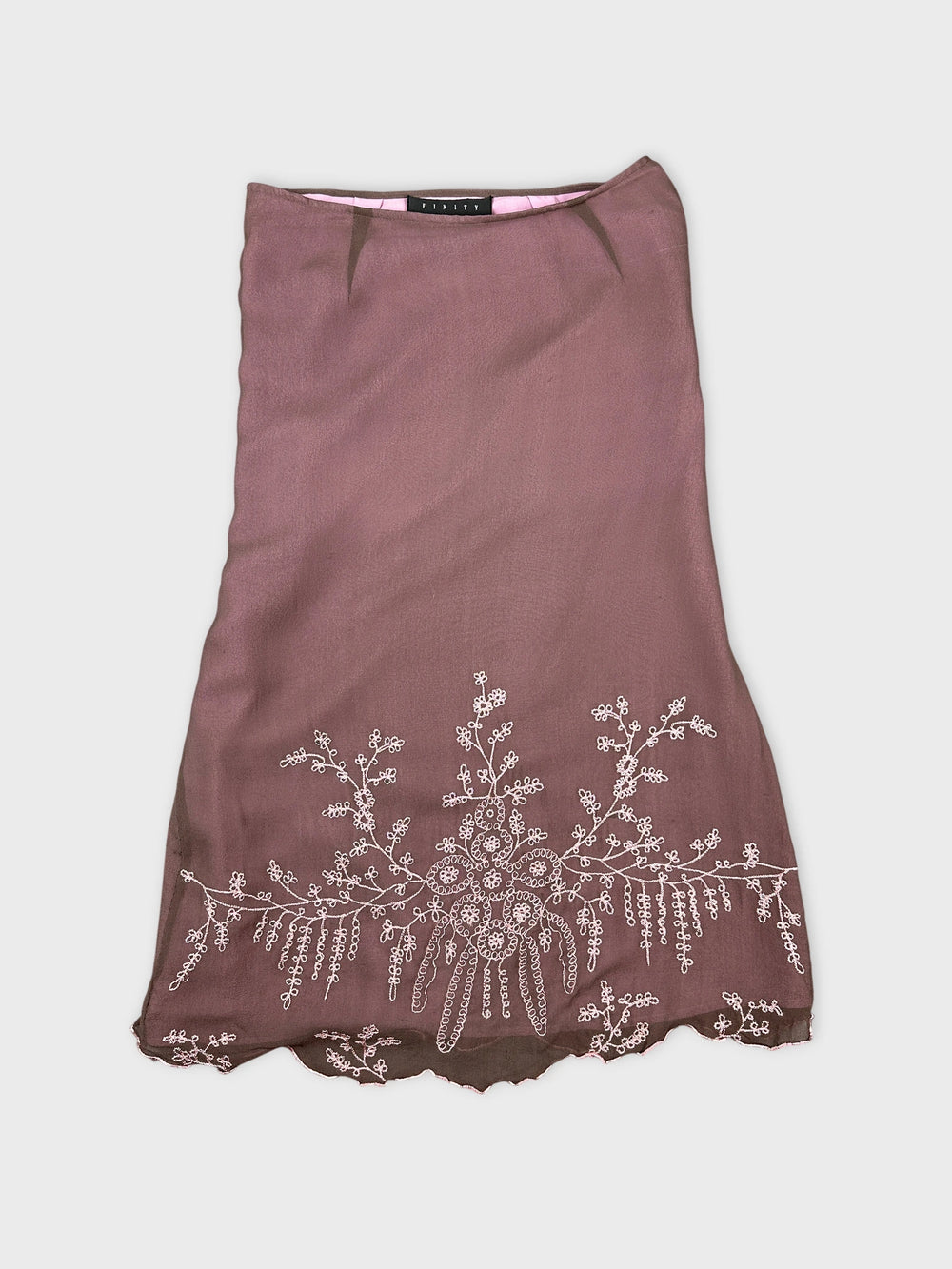 Front view of a vintage brown skirt with floral embroidery detail.