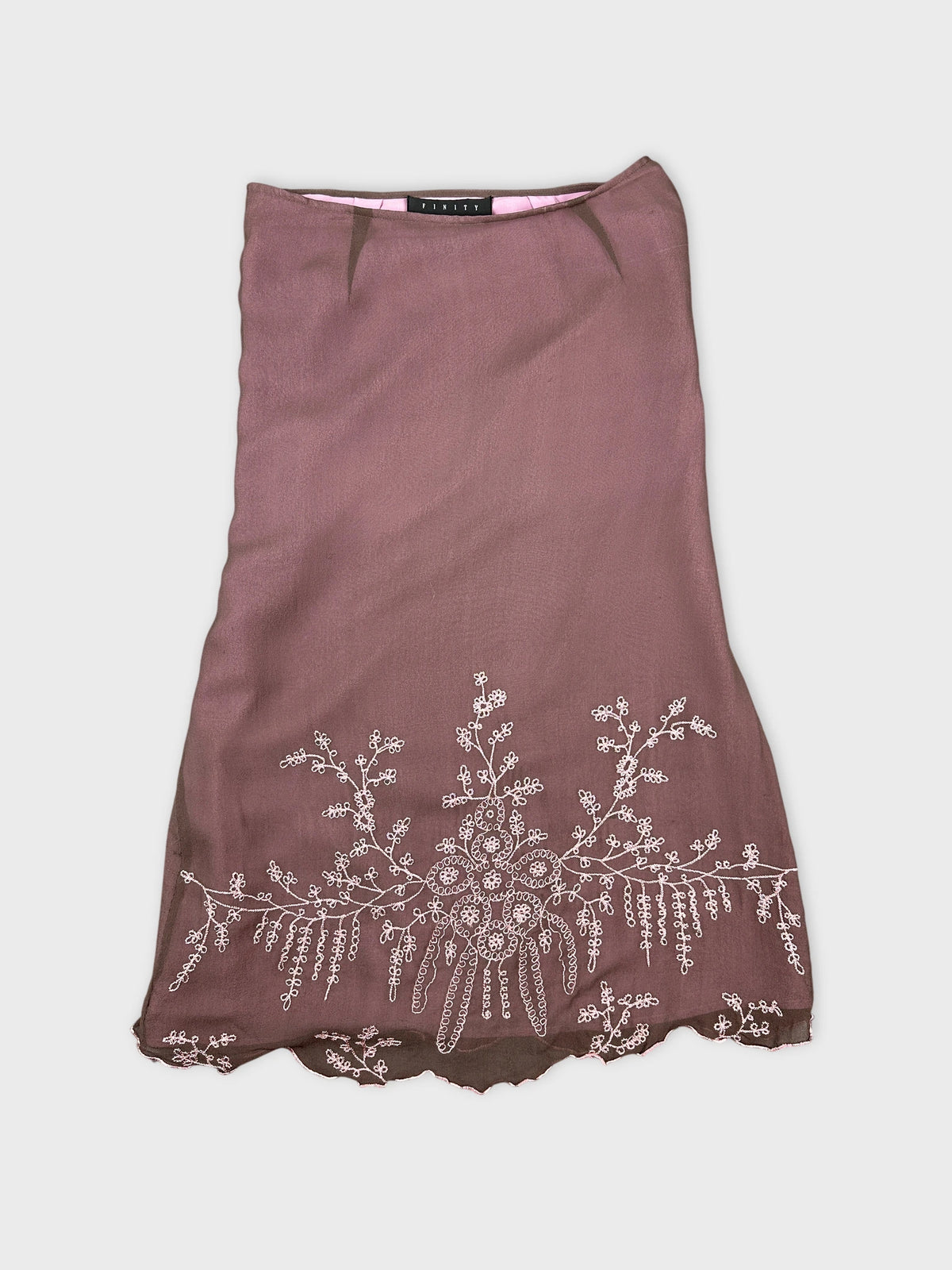 Front view of a vintage brown skirt with floral embroidery detail.