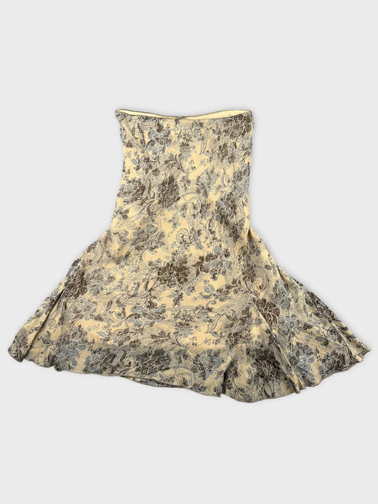Front view of a floral patterned yellow skirt with a flared shape.