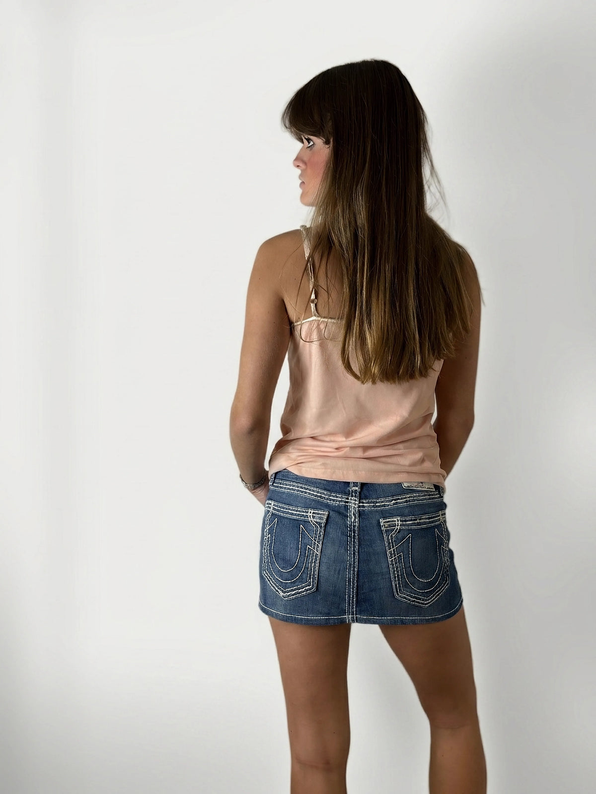 Back view of a denim skirt featuring distinctive stitched back pockets.