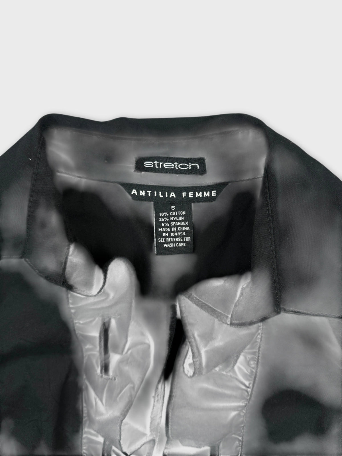 Detail view of a black vintage women’s shirt with a structured collar.
