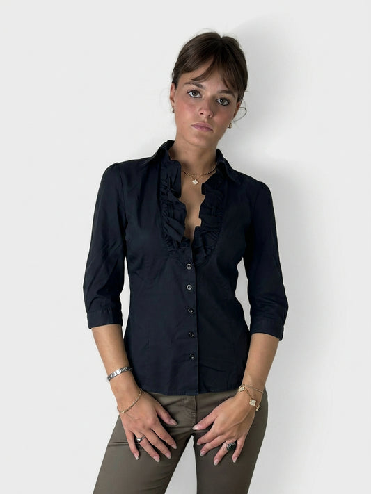 Front view of a black button-up shirt featuring ruffled collar details.