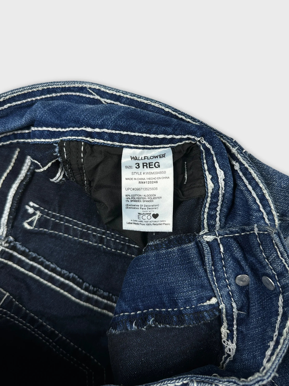 Detail view of wide jeans in dark blue with contrast stitching.