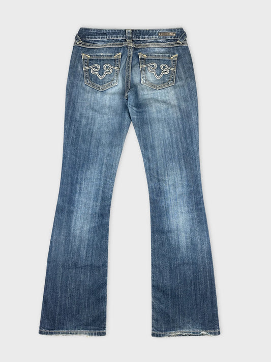 Back view of blue denim jeans featuring decorative stitching on pockets.