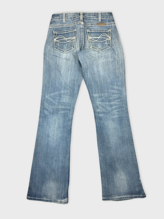 Back view of blue denim jeans featuring decorative stitched pockets.