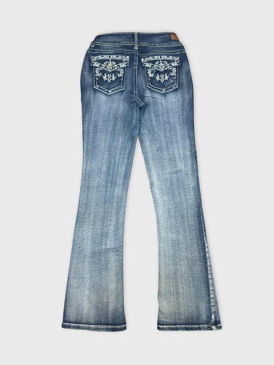 Back view of blue denim jeans featuring embroidered pockets