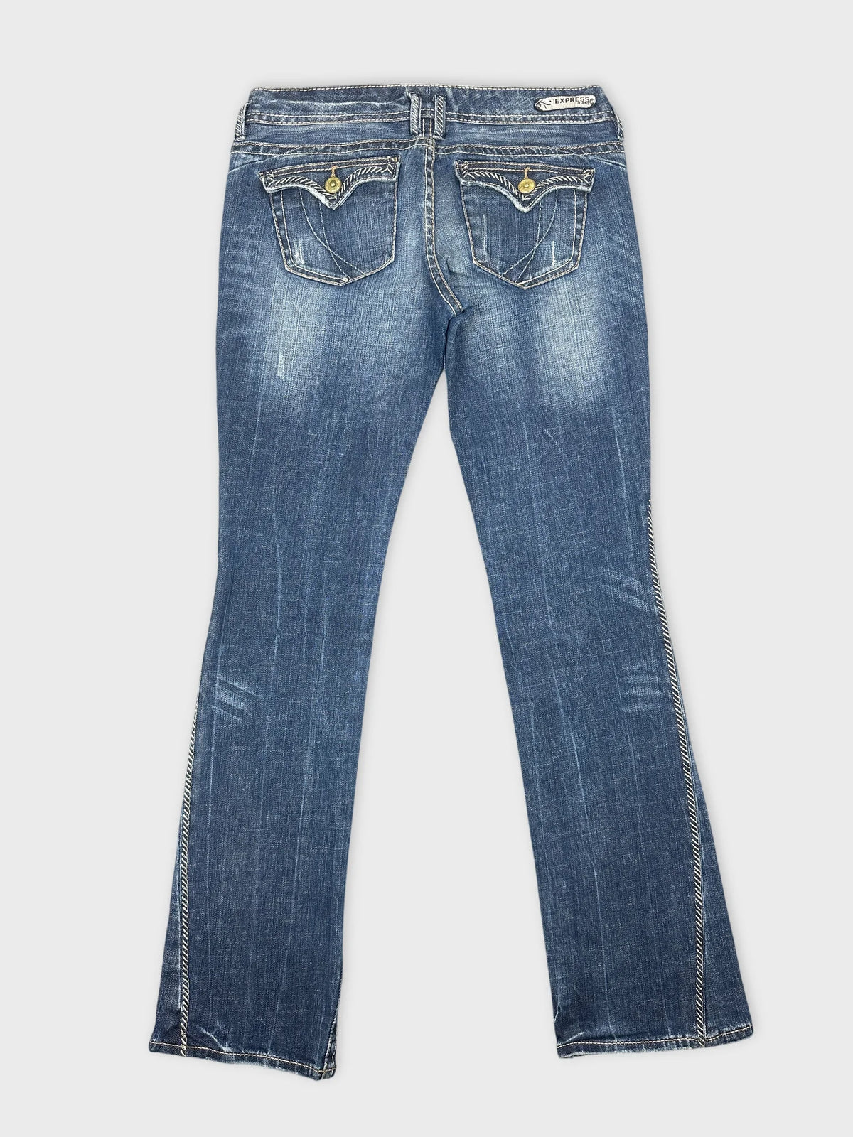 Back view of blue denim jeans featuring two back pockets with decorative stitching.