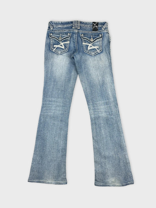 Back view of blue denim jeans featuring decorative back pockets.