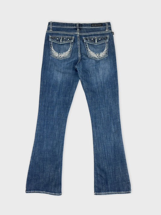 Back view of blue denim jeans featuring embroidered wing details on pockets.