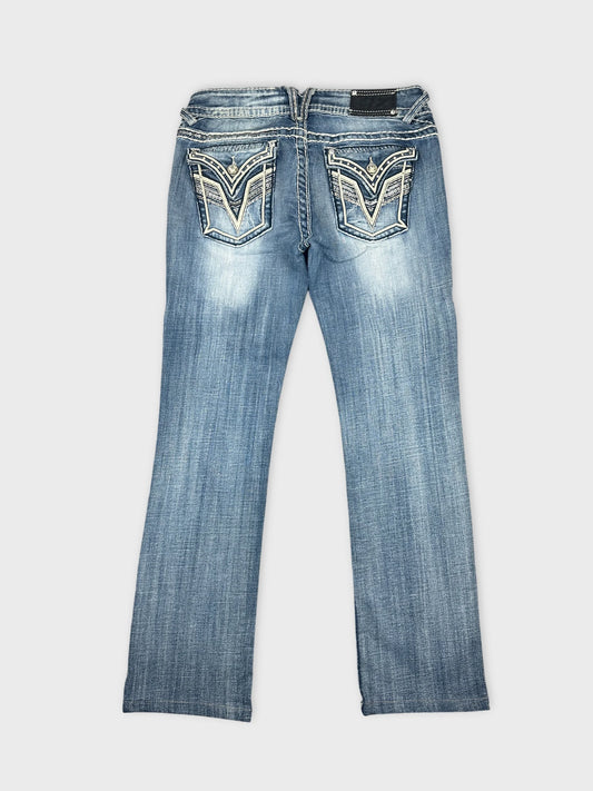 Back view of denim jeans in light blue with detailed back pockets.
