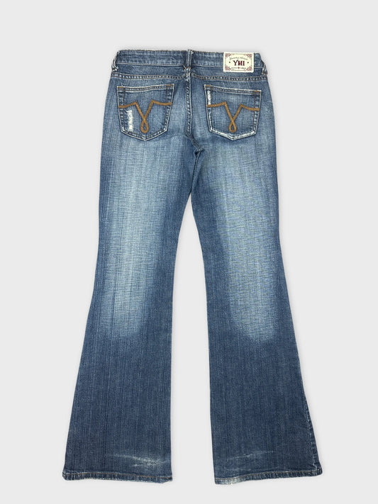 Back view of women denim jeans in light blue with decorative stitching.