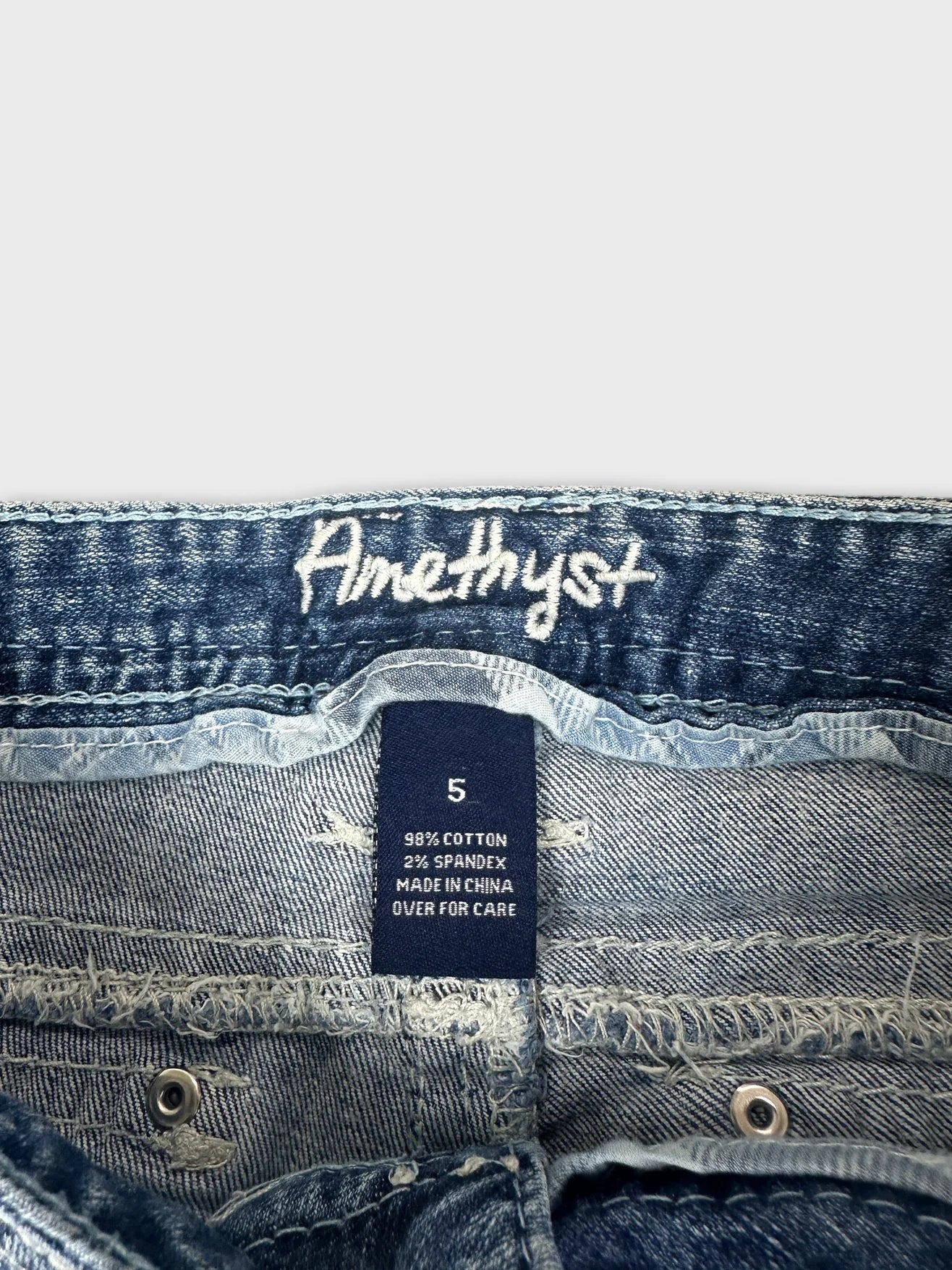 Detail view of women denim jeans in blue with embroidered brand logo