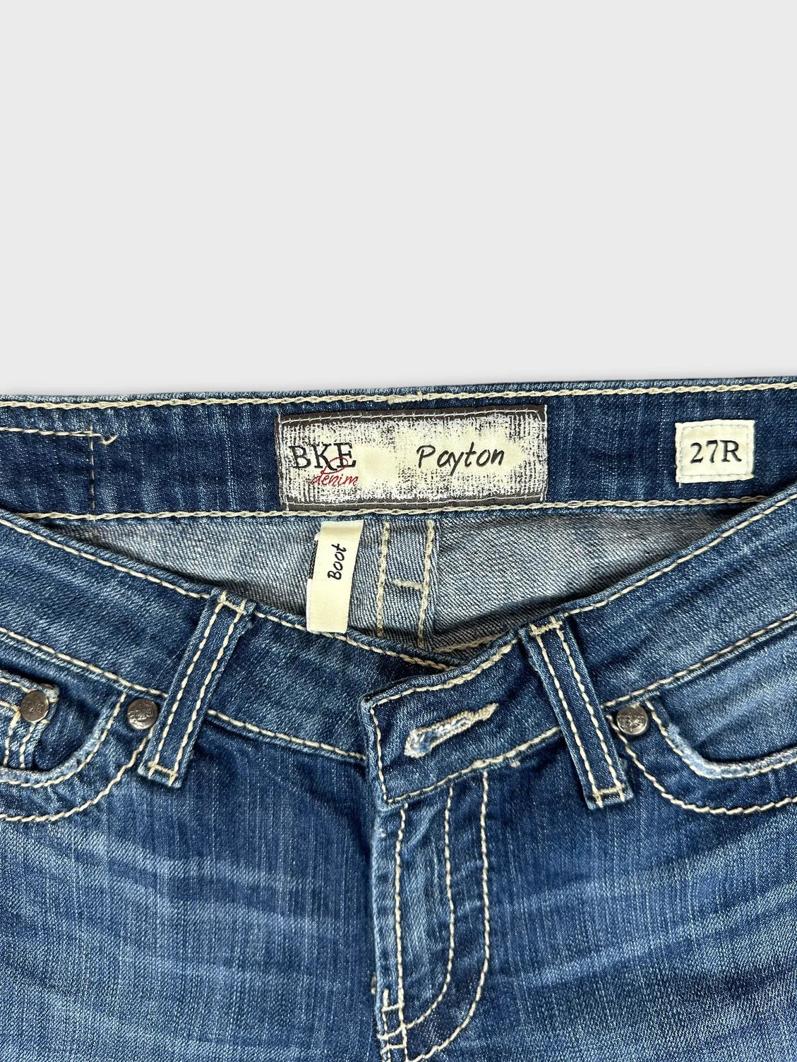 Detail view of women denim jeans in medium blue with contrasting stitching.