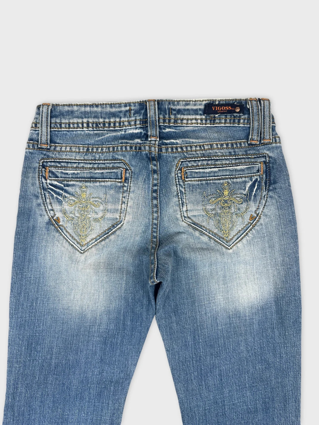 Detail view of women denim jeans in light blue with embroidered back pockets.