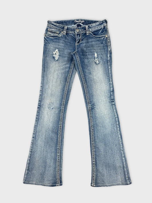 Front view of women denim jeans in light blue with distressed details.