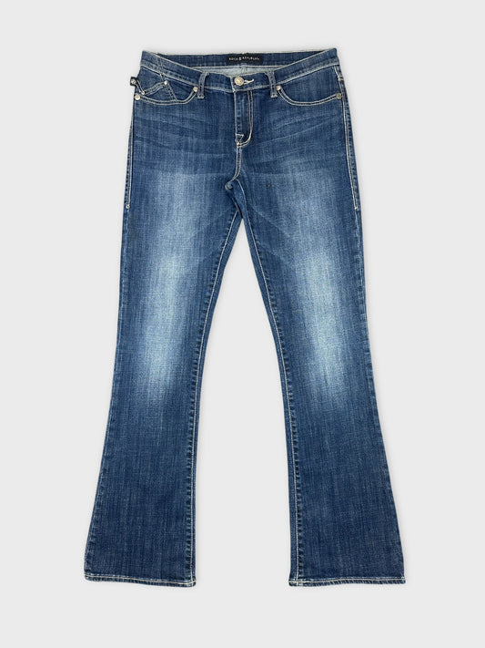 Front view of women's denim jeans in dark blue with a flared shape.