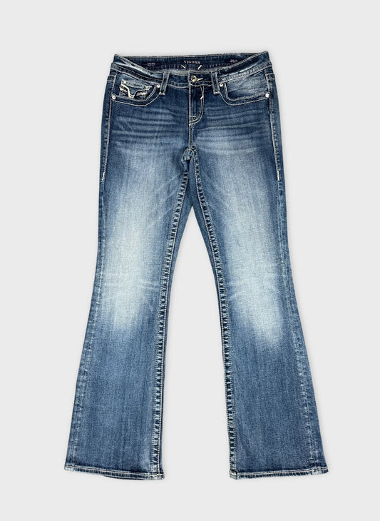 Front view of women's denim jeans in blue with flared legs.