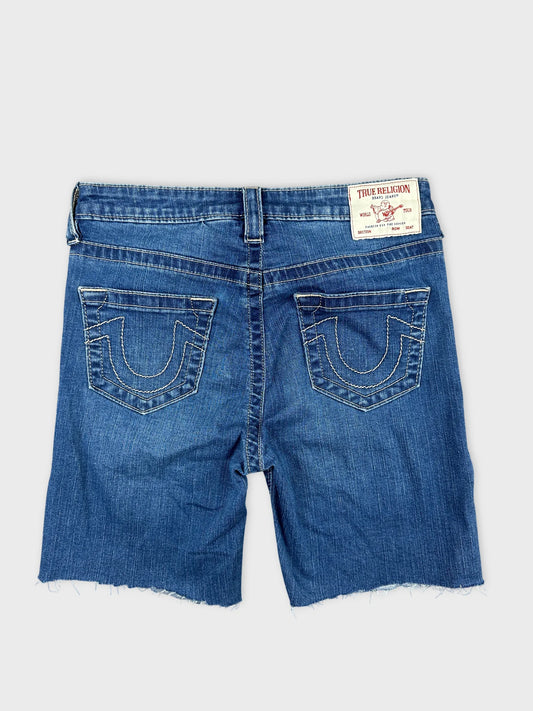 Back view of blue denim midi shorts featuring stitched pocket detailing.