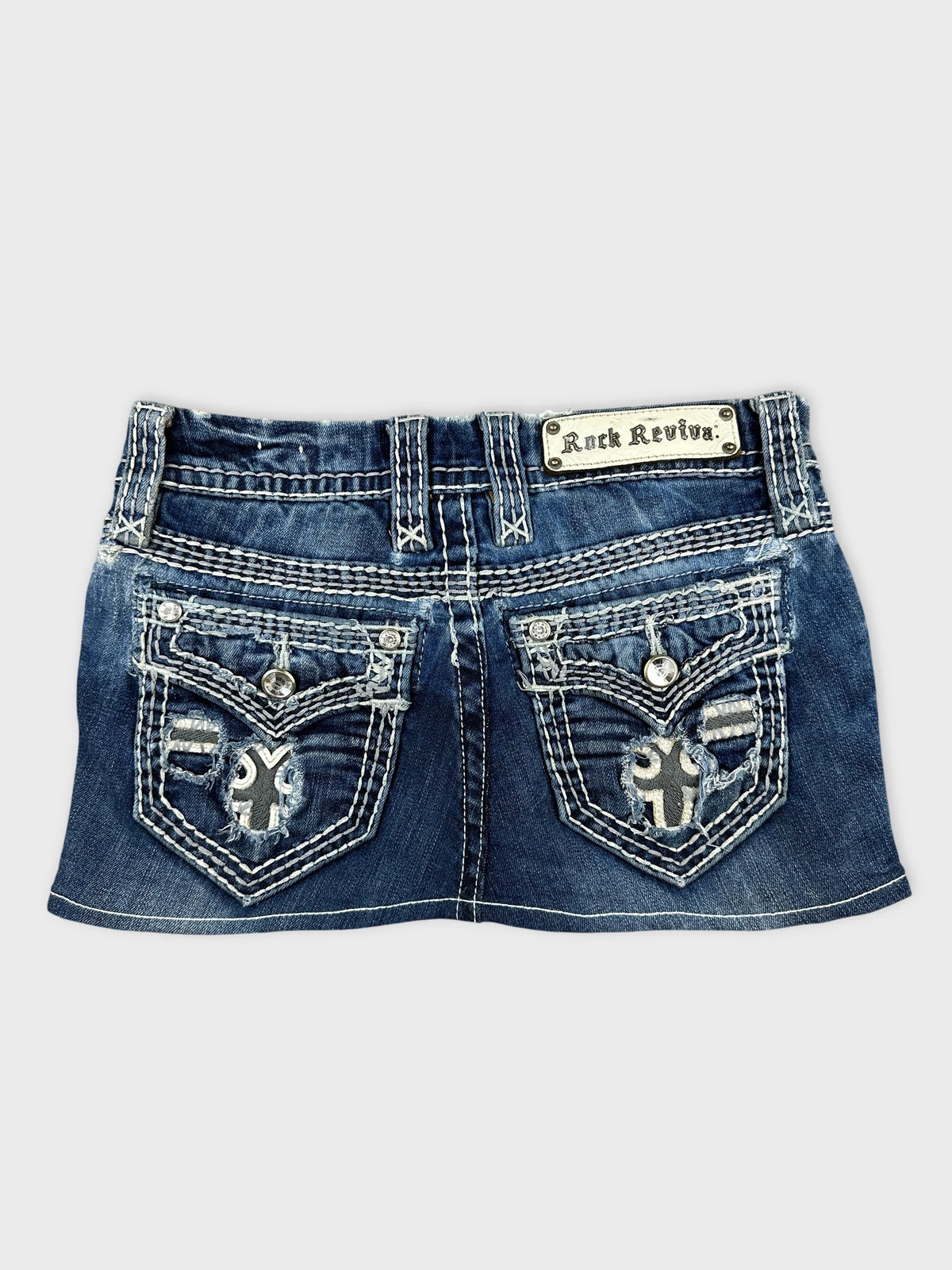 Back view of a women's denim shirt in blue with detailed pocket embroidery.