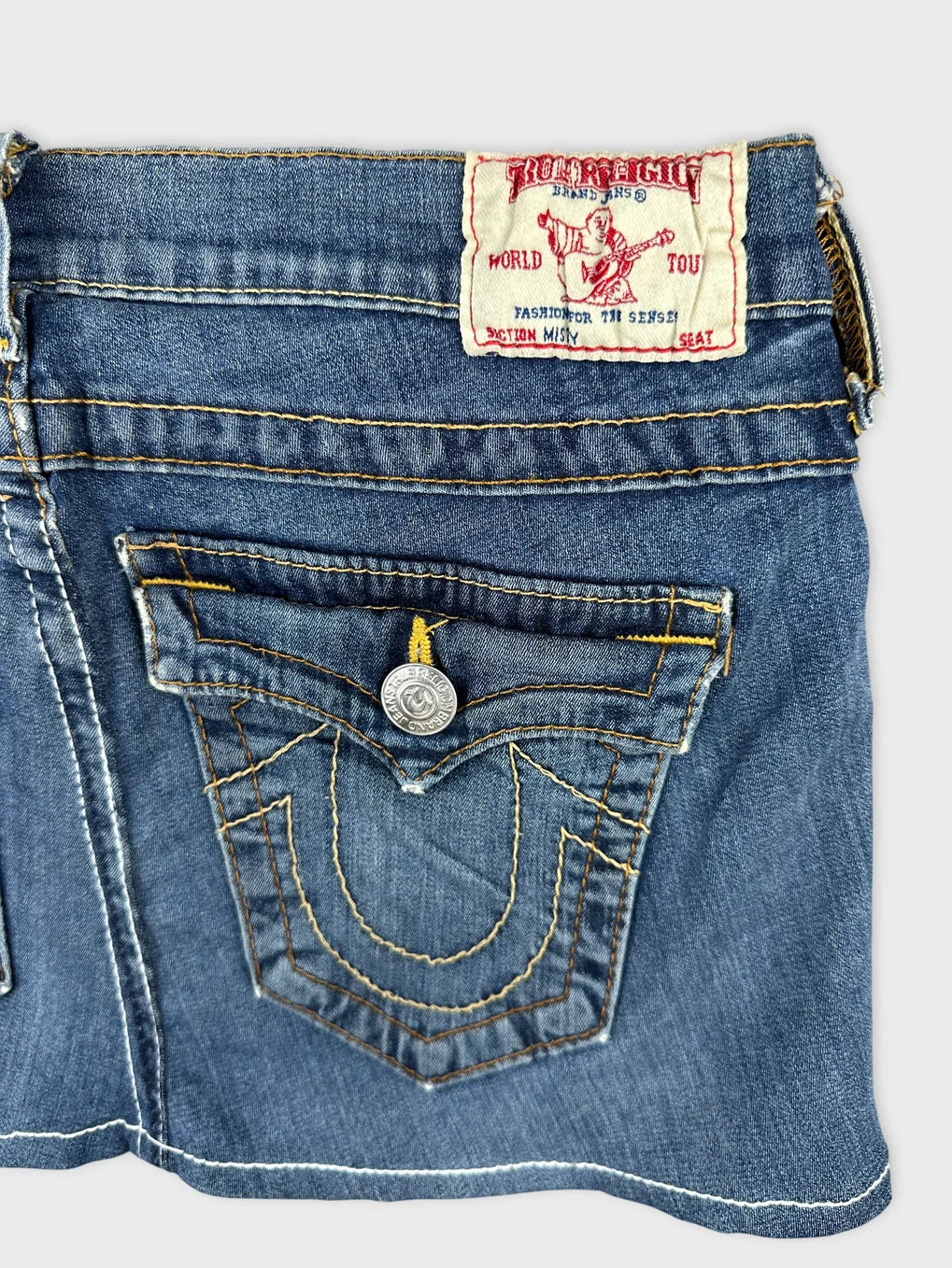 Detail view of a blue denim shirt featuring a unique stitched pattern.