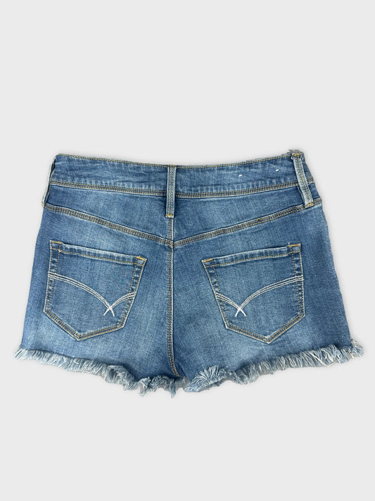 Back view of women denim shorts in light blue with frayed hem.