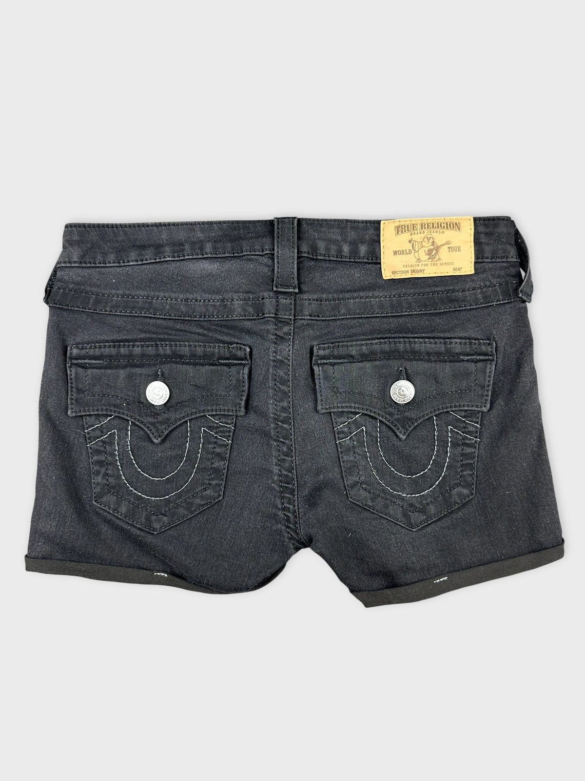 Back view of black denim shorts with detailed back pockets and label.