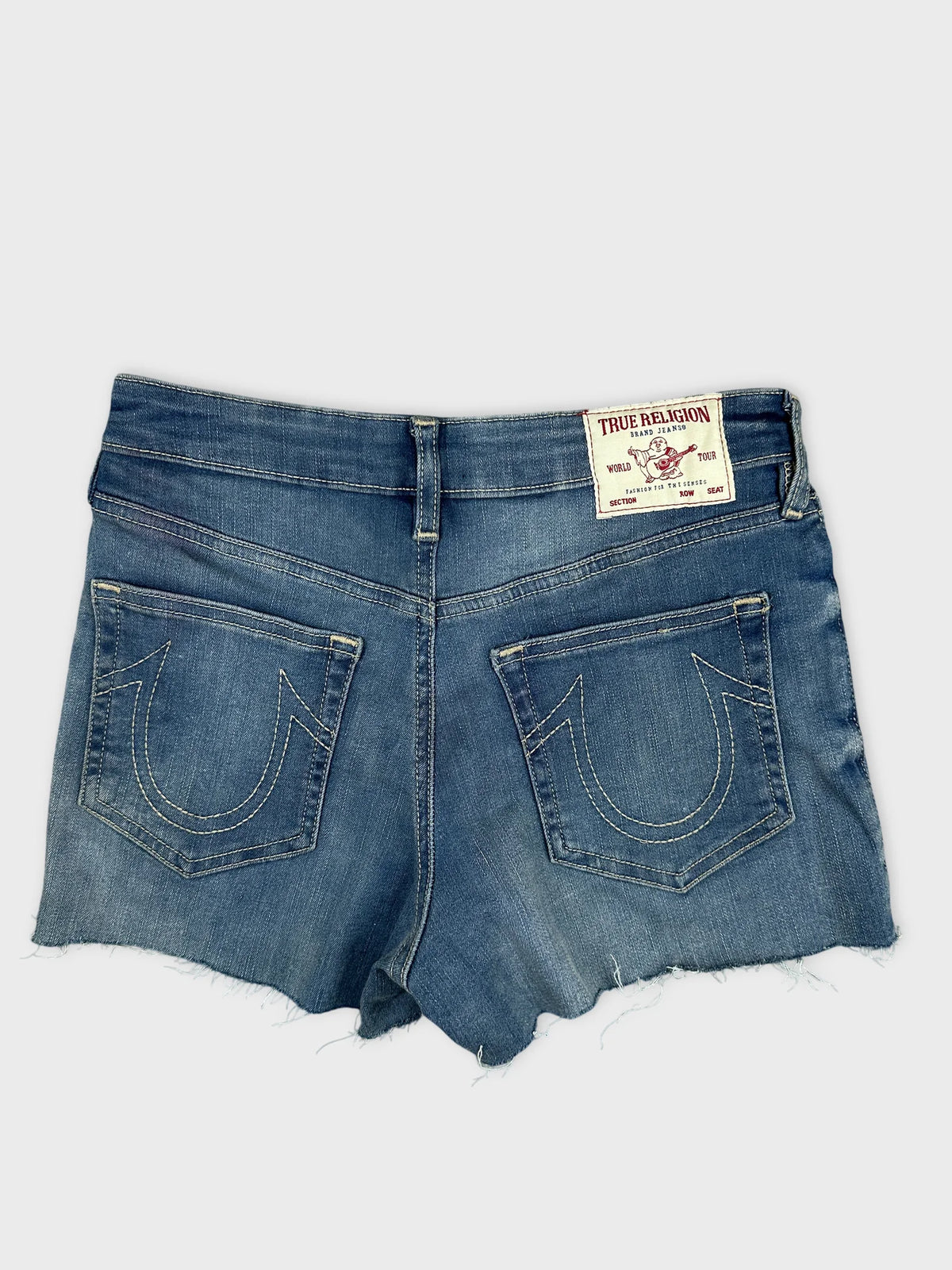 Back view of denim shorts featuring a faded blue color and signature embroidered pockets.