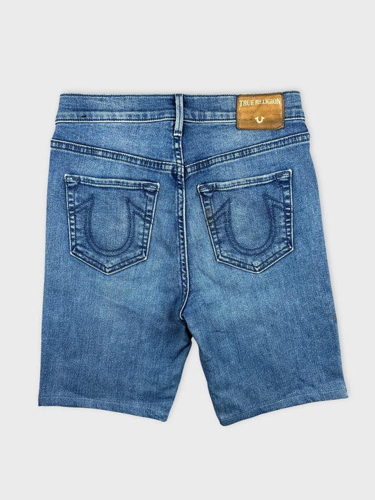 Back view of blue denim shorts with visible True Religion label and detailed stitching.