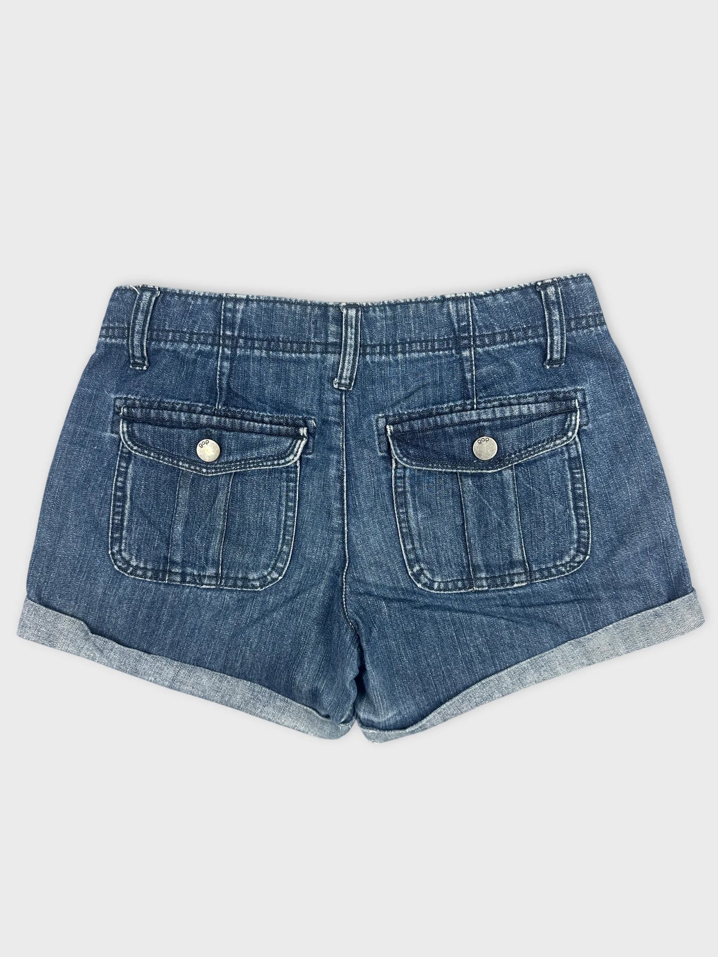 Back view of blue denim shorts with pocket detailing and rolled hems.