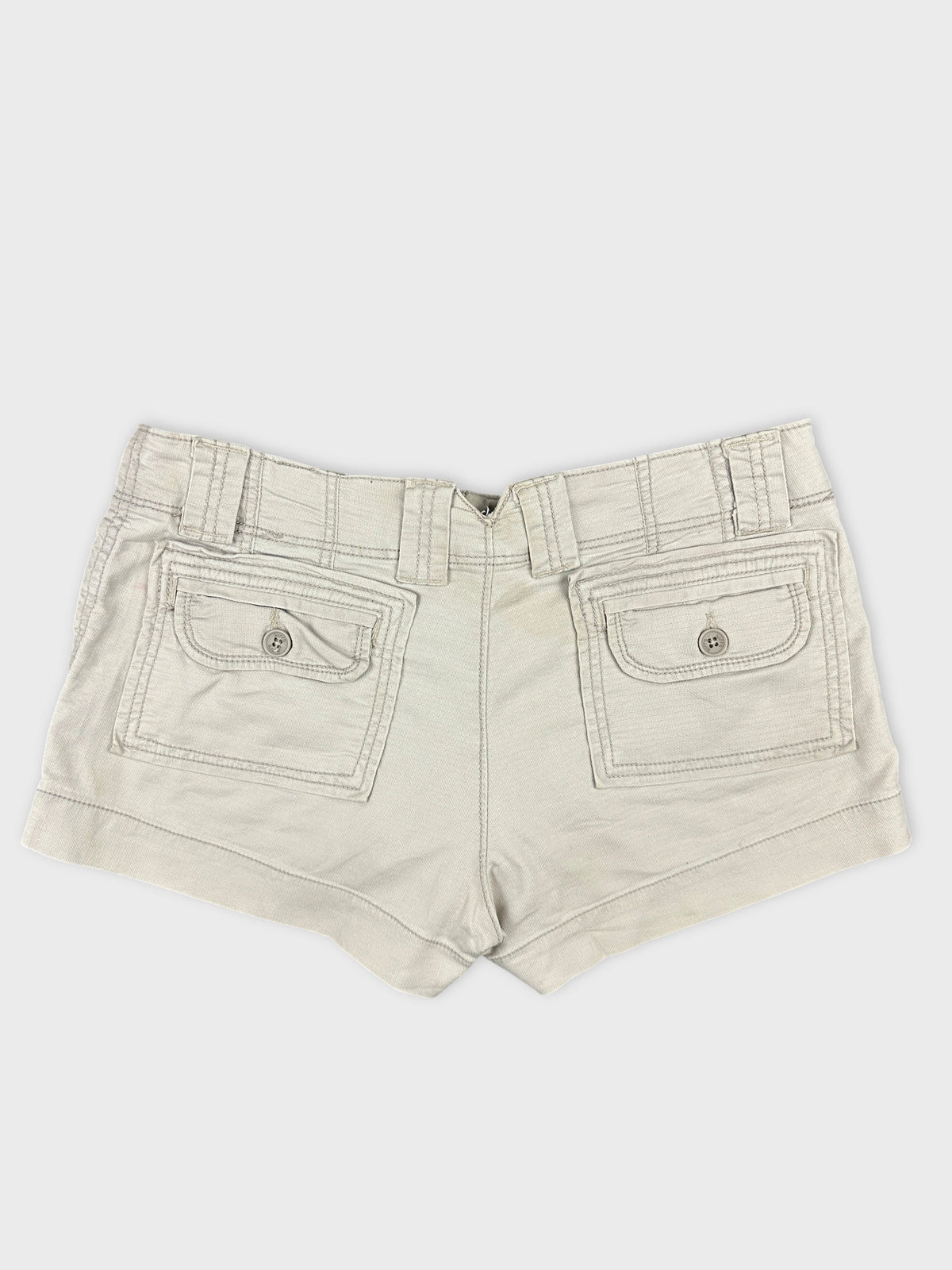 Back view of women denim shorts in light beige with two back pockets.